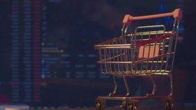 Modern economy. Business concept. A small empty shopping cart stands against the background of a computer monitor on which economic data is changing. Close-up. Shallow depth of field. - Powered by Shutterstock - Get 15% off with code: PIKWIZARD15