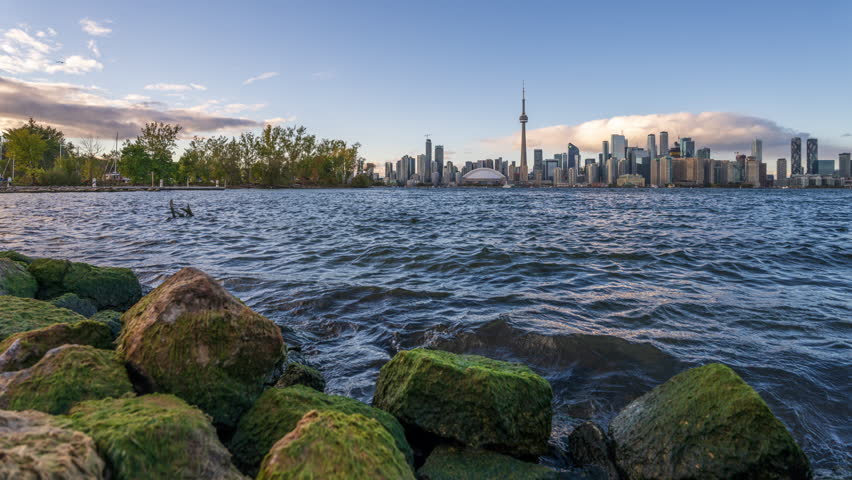 Toronto, Ontario, Canada downtown skyline on Lake Ontario from dusk till night.