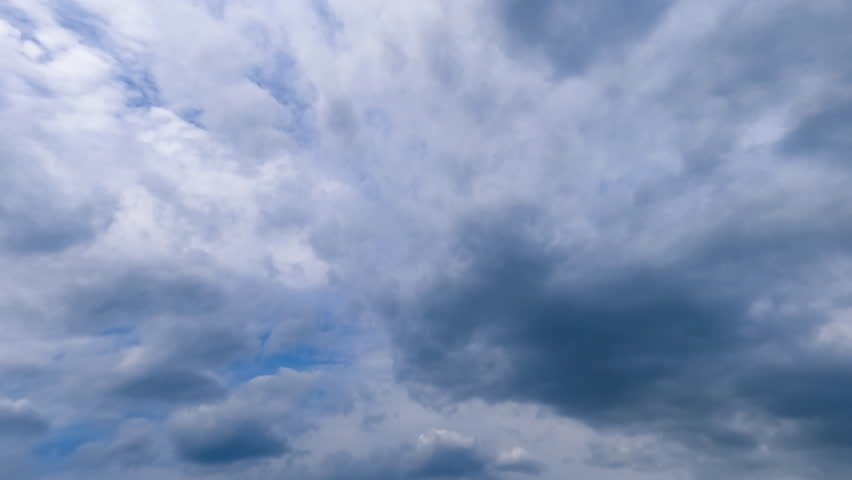 Rain formation in the atmosphere. Clouds of diverse size, shape and kind float quickly in the sky. Low angle view. Timelapse.