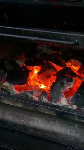 Cooking steak on the grill and coals. Roasting steak in a restaurant. Vertical video.