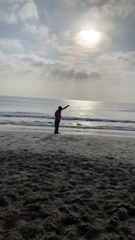Catching fish from the beach at sunset