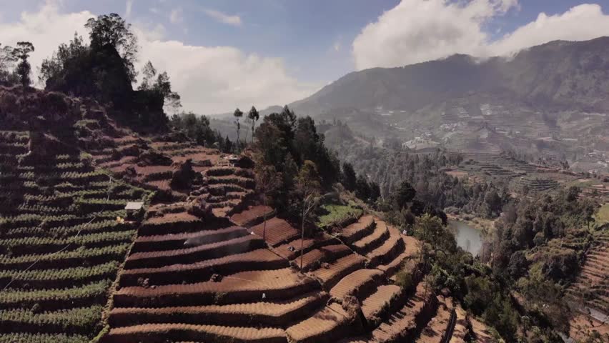 beautiful hilly scenery with green-clad curves of hills, surrounded by valleys, set against a backdrop of mountain slopes and bright white clouds. calm lake The water is turquoise blue.