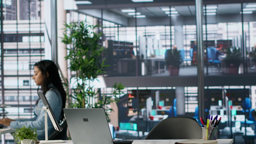 Businesswoman gathering her office belongings in a box after getting fired, feeling frustrated and stressed over unemployment. Jobless person leaving her workstation, job failure. Camera A.