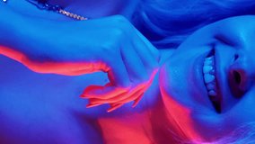Vertical video. Neon light smile. Festive mood. Celebration joy. Cheerful happy glamour party woman in night blue pink red glow. - Powered by Shutterstock - Get 15% off with code: PIKWIZARD15