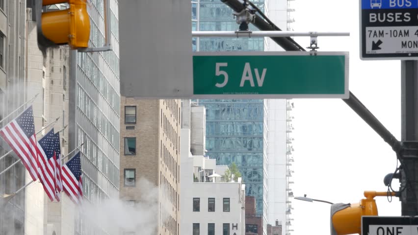 Fifth avenue, 5 ave road sign, Manhattan midtown architecture, New York City 5th av street corner. Traffic crossroad signage, USA. American flag, United States. Steam vapor stack, hot vapour smoke.