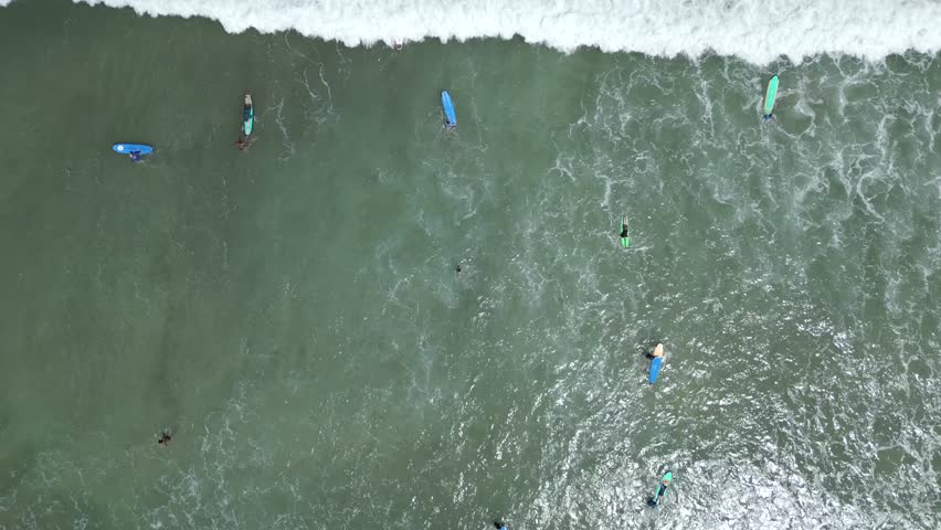 Aerial view of people taking surfing lessons in the ocean, Bali, Indonesia