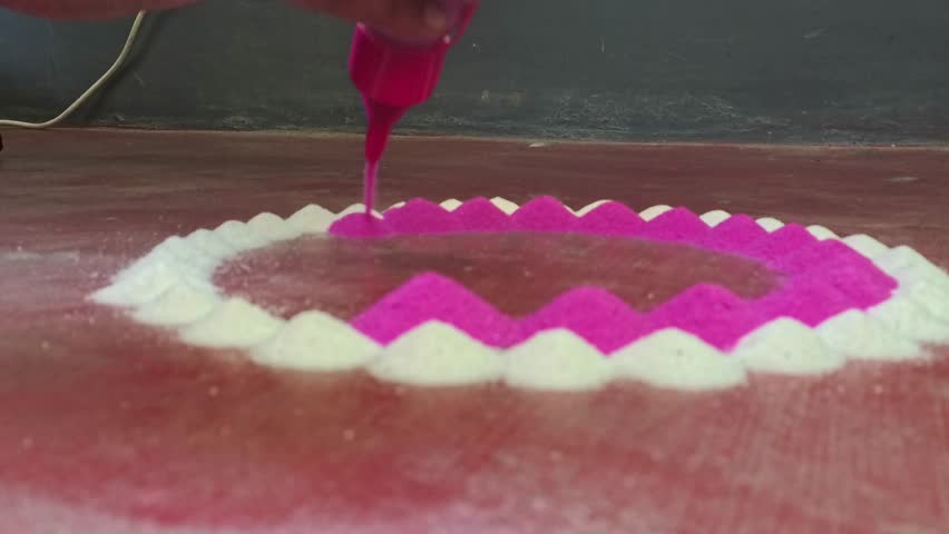 4k video clip of making colorful rangoli design on the floor by an Indian female in a simple way