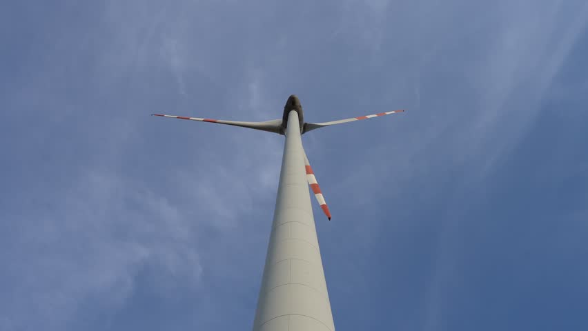 Powerfull wind turbine with blades slowly moving. Generating clean renewable energy electricity. Nothing but a wind power sustainable Energy. View from below
