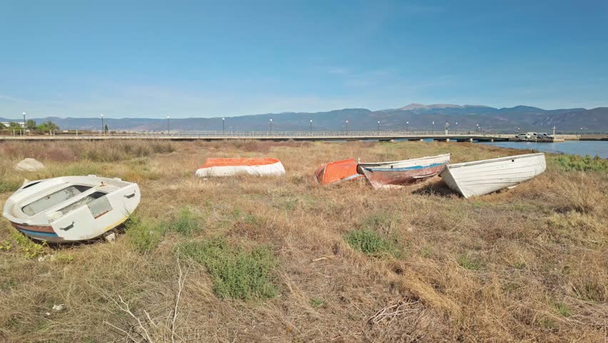 Derelict Greek wooden fishing boats neglected on grassy beach