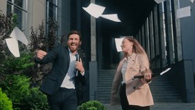 Happy successful Caucasian two coworkers colleagues businessman business male guy man businesswoman girl female woman walking city celebrate throwing papers documents in air achieve project complete - Powered by Shutterstock - Get 15% off with code: PIKWIZARD15