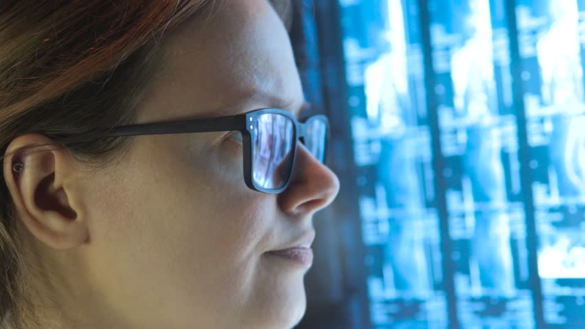 Portrait of female doctor in glasses reading X-ray scans MRI images. Close up. - Powered by Shutterstock - Get 15% off with code: PIKWIZARD15