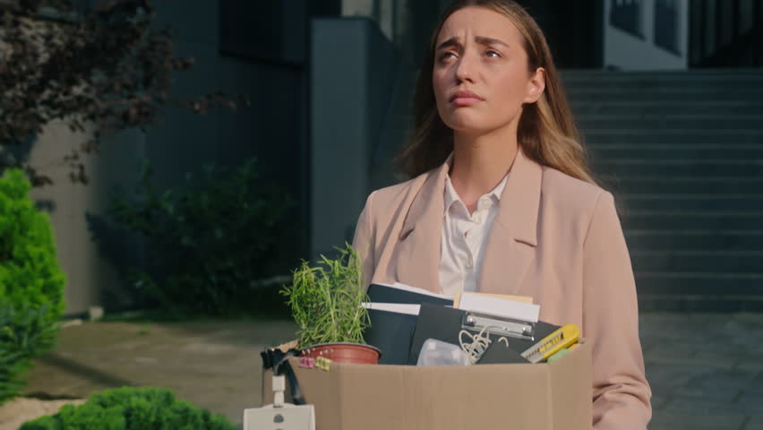 Caucasian stressed fired female woman girl lady with dismissal box leaving office businesswoman dismissed from work business dismiss unemployment walk in city walking sad financial crisis disappointed