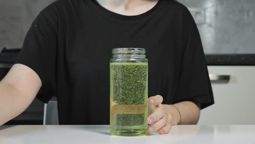 The girl closes the lid of the oil container. Adding oil to the oil container