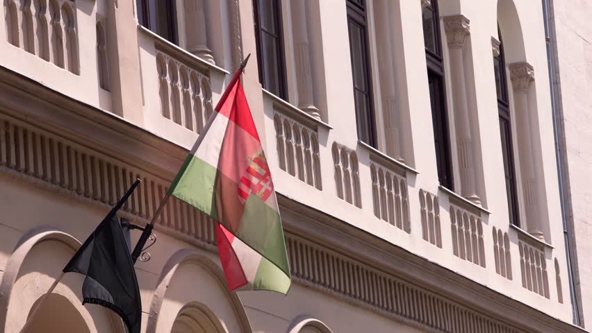 Slow motion of the Hungarian flag displayed on a historical building in Budapest, a close view symbolizing the nation