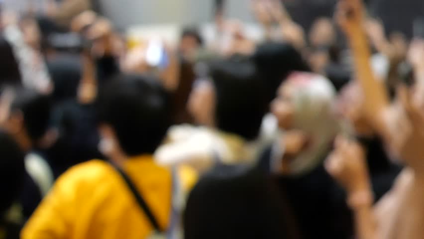 Crowded fans using mobile phones to take photos of celebrity