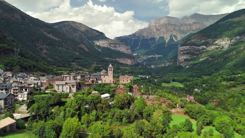 Aerial view of the Torla-Ordesa village and Ordesa-Monte Perdido National Park in the Spanish Pyrenees mountains. Medieval buildings and the Church of San Salvador in Torla-Ordesa, Huesca, Spain.