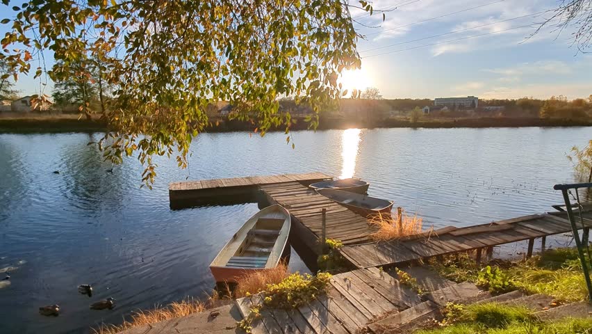 boats at the pier on the river in autumn sunset