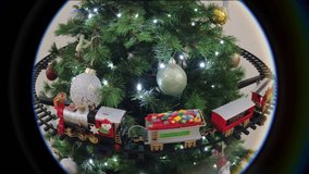 Toy Christmas train moving around a beautiful Christmas tree surrounded by colorful balls - Powered by Shutterstock - Get 15% off with code: PIKWIZARD15