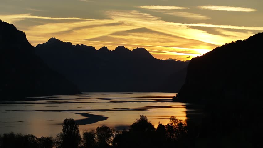 Breathtaking View Of Mountain Range And Walensee Lake With Calm Waters During Sunset In Switzerland. - aerial shot