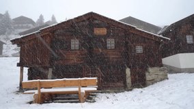 A wooden mountain hut on the Bettmeralp in Switzerland. Heavy snowstorm and snowy winter landscape in Switzerland - static shot - Powered by Shutterstock - Get 15% off with code: PIKWIZARD15