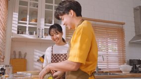 Asian young new marriage couple spend time together in kitchen at home. Attractive man and woman feeling happy and relax, enjoy cooking foods for breakfast with happiness. Family relationship concept. - Powered by Shutterstock - Get 15% off with code: PIKWIZARD15
