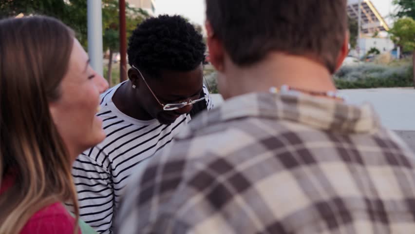 Diverse Group of College or High School Students Share Cheerful Moments Between Classes, Carrying Folders and Backpacks While Leaning. Teenage Classmates talking and having a friendly conversation - Powered by Shutterstock - Get 15% off with code: PIKWIZARD15