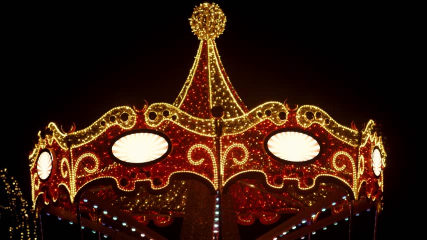 Christmas Holidays. Sparkling red Carousel in the dark.Christmas Light Installations. Red gold shining fairground carousel. 4k footage