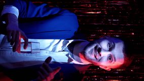 Vertical video. Xmas toast. Happy New Year. Holiday congratulation. Excited party man saying nice words best wishes with champagne glass cheers in blue red neon light. - Powered by Shutterstock - Get 15% off with code: PIKWIZARD15