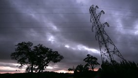Electricity lines and pylon silhouetted in front of moody timelapse sky - Powered by Shutterstock - Get 15% off with code: PIKWIZARD15