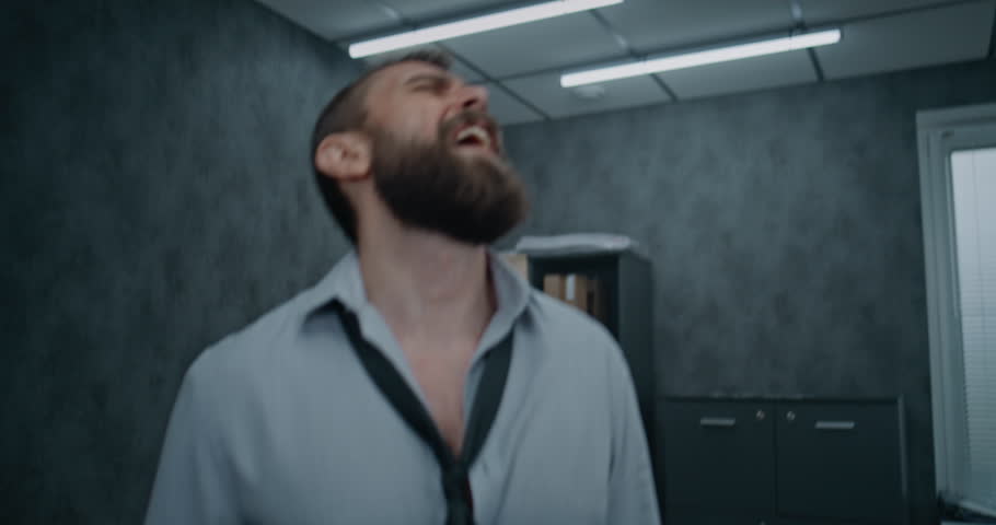 Furious office employee loses temper, screams, walks nervously after destroying office room. Aggressive businessman in fit of rage after failed business deal. Financial crisis or firing. Job burnout.