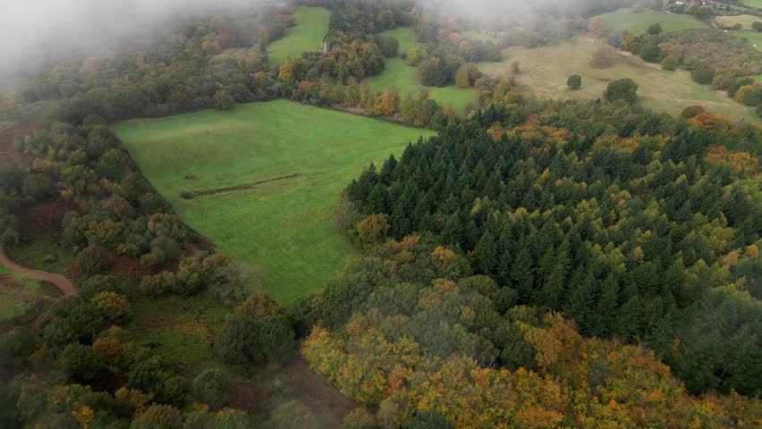 Drone aerial view over the British countryside in misty autumn weather with low cloud