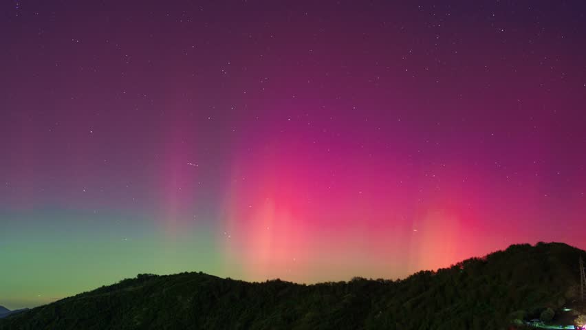 Northern Lights timelapse over a mountain range near Genoa, Italy in a vibrant night sky