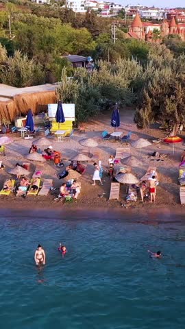 Vertical video of the beach - high quality vertical video taken from the air with a drone of people swimming and sunbathing in summer
