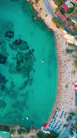 Vertical video of the beach - high quality vertical video taken from the air with a drone of people swimming and sunbathing in summer