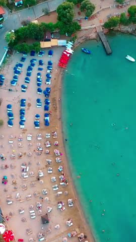 Vertical video of the beach - high quality vertical video taken from the air with a drone of people swimming and sunbathing in summer