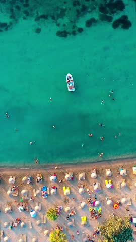Vertical video of the beach - high quality vertical video taken from the air with a drone of people swimming and sunbathing in summer