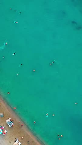 Vertical video of the beach - high quality vertical video taken from the air with a drone of people swimming and sunbathing in summer