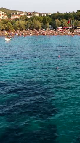 Vertical video of the beach - high quality vertical video taken from the air with a drone of people swimming and sunbathing in summer