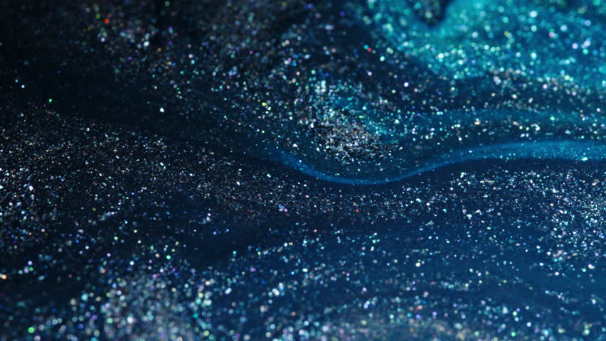 Sparkling blue and silver particles swirl and blend in a mesmerizing macro shot