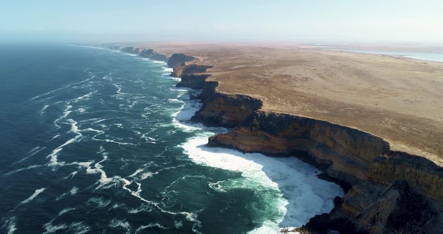 Drone aerial dolly along Great Australian Bight with dramatic cliffs meeting the expansive ocean in South Australia, stunning natural textures and contrast between land and sea