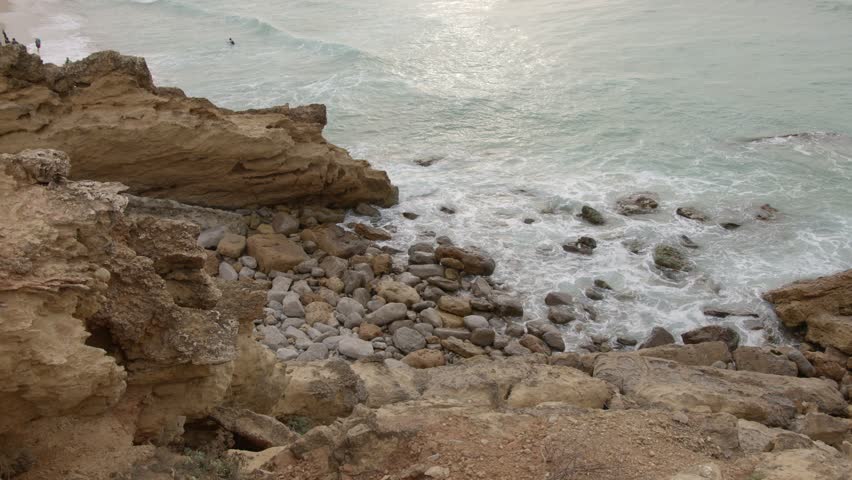 Waves crashing in beach rocks 
