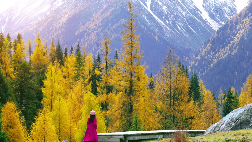 Tourist walking at Shuangqiao valley in autumn, Mount Siguniang in Sichuan Province, China.
