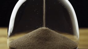 Timelapse shot of golden glittering sand grains leaking in an hourglass, extreme close up view. Passing time concept. - Powered by Shutterstock - Get 15% off with code: PIKWIZARD15