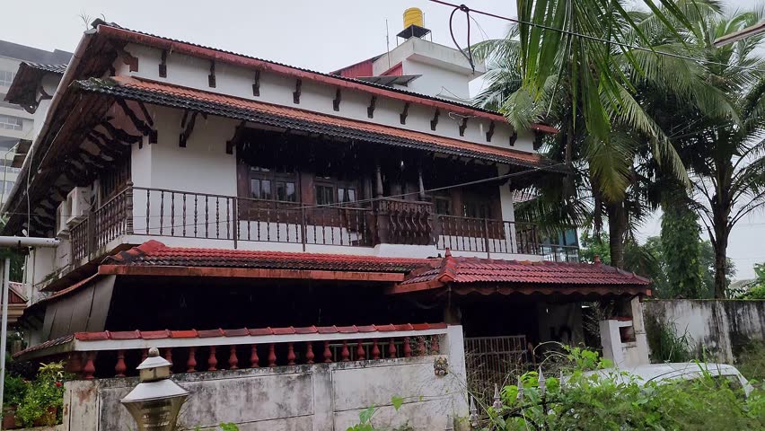 A video shows heavy rain pouring over the big beautiful old house in village during the monsoon season