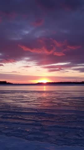 Beautiful sunset over frozen lake in winter