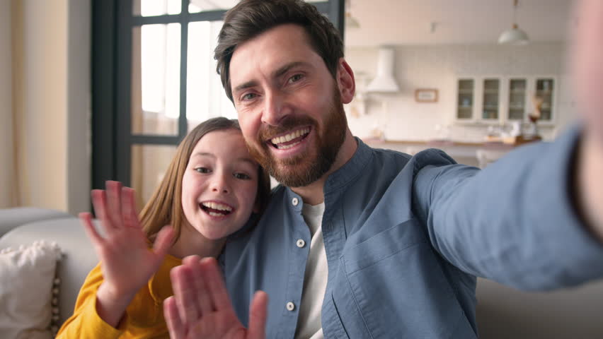 POV phone happy smiling Caucasian family video call dad male parent type screen mobile button webcam man father talking kid recording blog little girl daughter child greeting wave hand hello at home