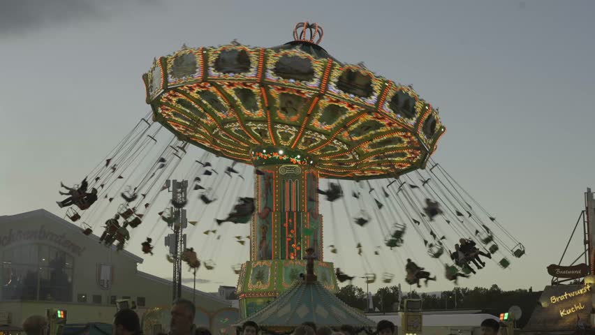 October 2, 2024. Munich, Germany. Viennese carousel at amusement park during Oktoberfest in evening with beautiful lighting. Wellenflug auf Wiesen Thereianwiese in Munchen. Wellenflieger Oktoberfest. 