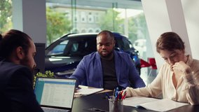 Customers negotiating correct price and financing options after finding right vehicle for them in showroom and deciding to buy it. Dealership clients reading contract terms and conditions, camera B - Powered by Shutterstock - Get 15% off with code: PIKWIZARD15