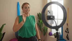 Woman recording fitness content on smartphone in gym wearing green shirt with exercise equipment in background - Powered by Shutterstock - Get 15% off with code: PIKWIZARD15