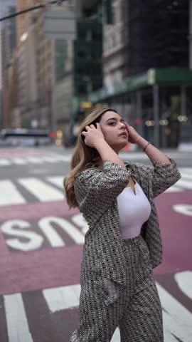 A sophisticated woman showcasing empowerment and modern style on a city street in a trendy checkered suit exudes confidence and urban backdrop highlights her dynamic presence. 5th avenue, New York.